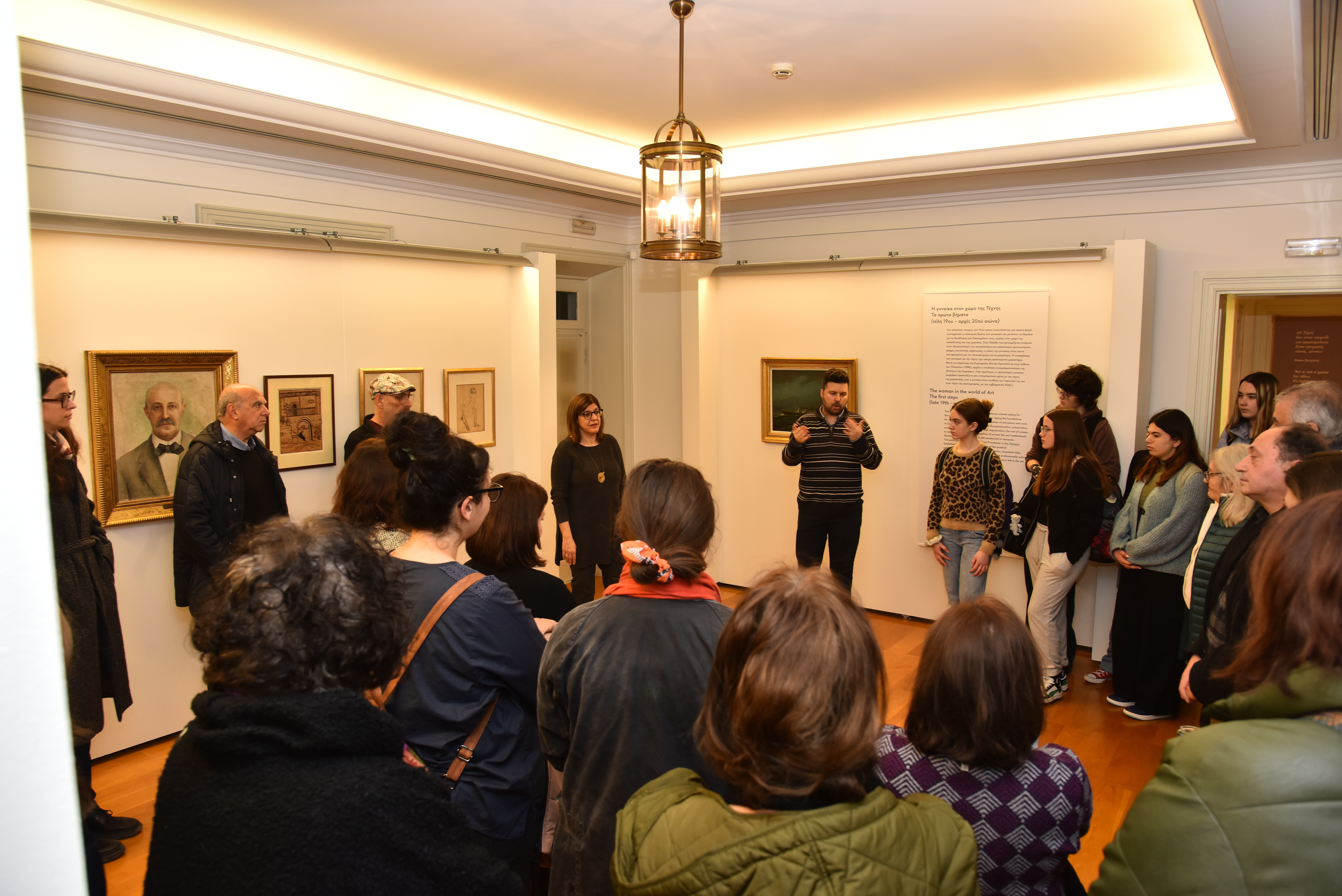 Women and men of various ages attending a guided tour inside a museum hall. Highlight from the guided tour