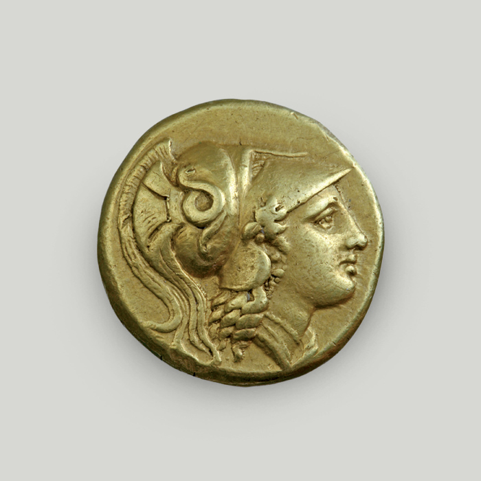 Εμπρόσθια όψη χρυσού διπλού στατήρα Μεγάλου Αλεξάνδρου με την κεφαλή της Αθηνάς σε προφίλ.  Εμπρόσθια όψη χρυσού διπλού στατήρα Μεγάλου Αλεξάνδρου