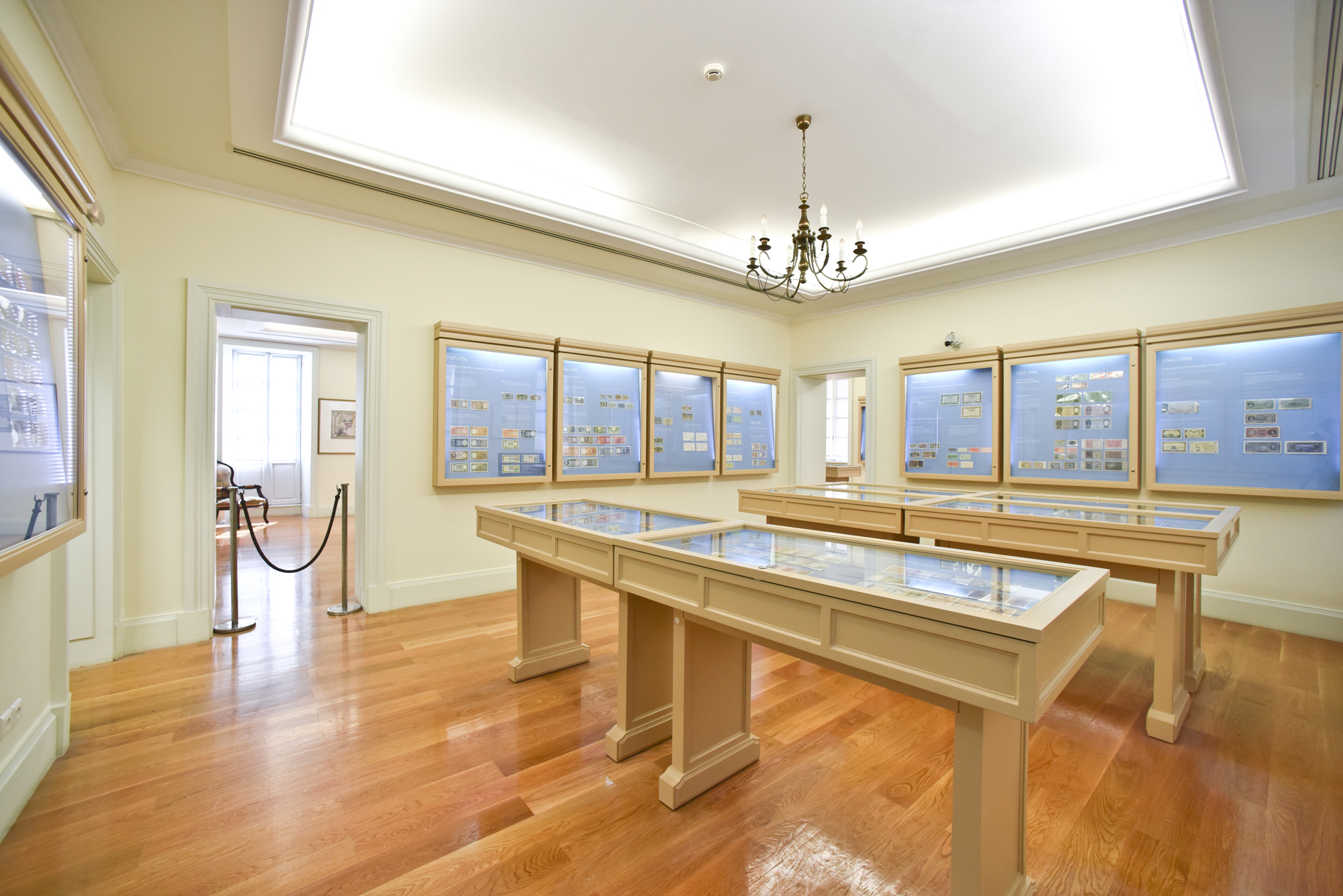 Hall at the Banknote Museum of Ionian Bank with coins in display cases.
