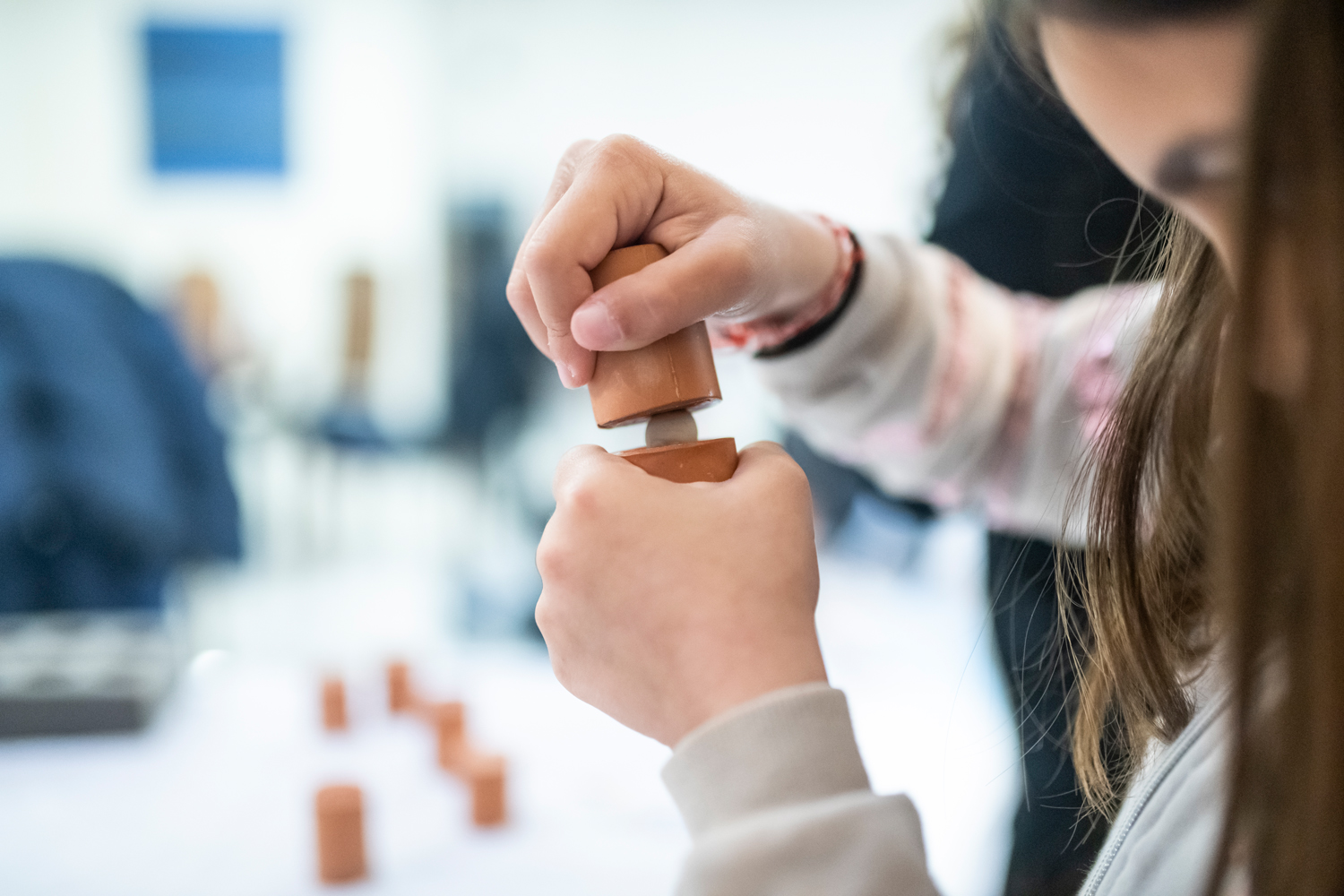 Female student making a coin using clay dies and modelling clay. Workshop at the Amfissa Cultural Centre
