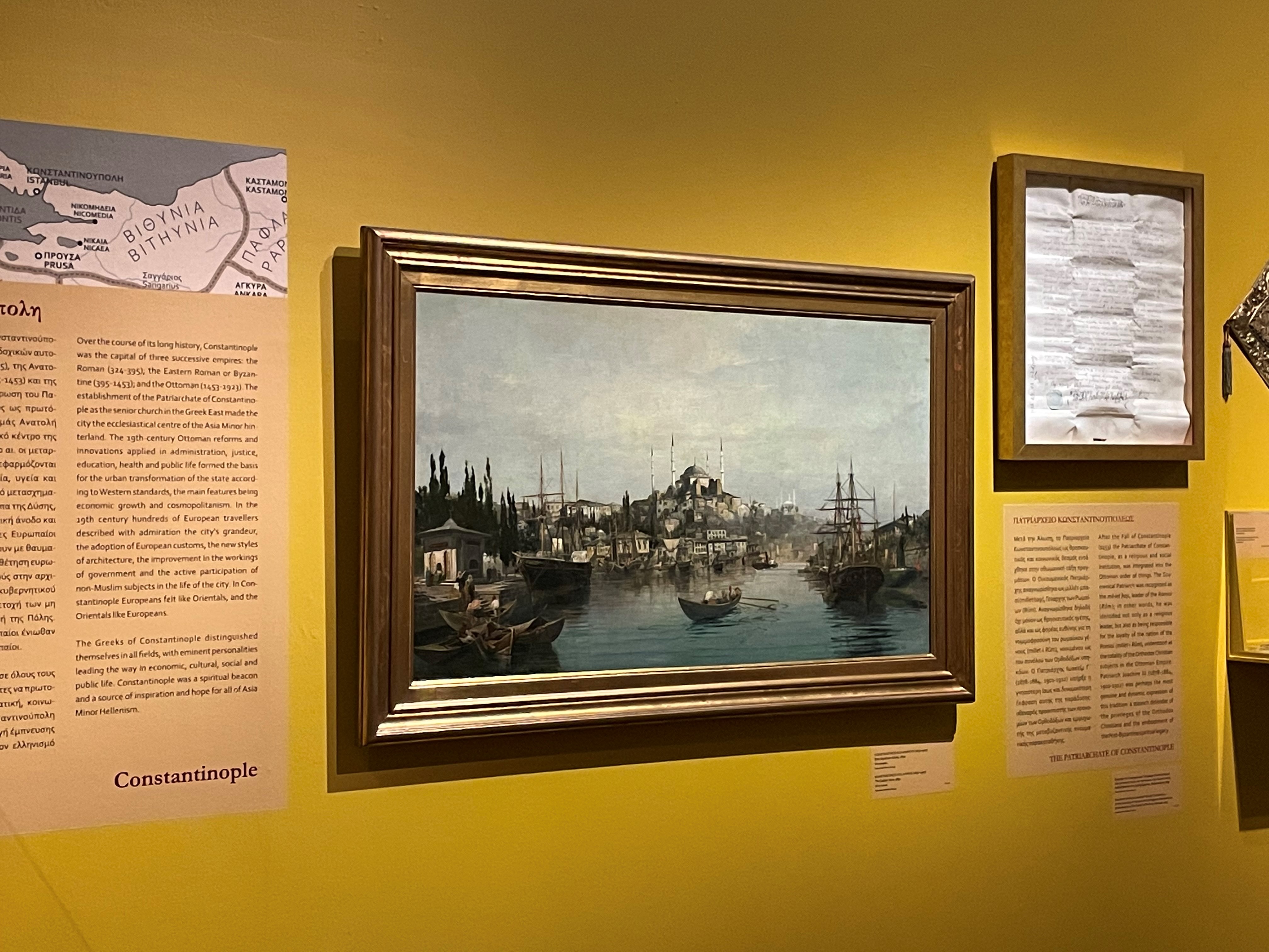 The work On the Golden Horn by Volanakis on a yellow wall. Hagia Sofia at the back and ships in the front.  Participation “Asia Minor: Splendour – Catastrophe – Uprooting – Regeneration”