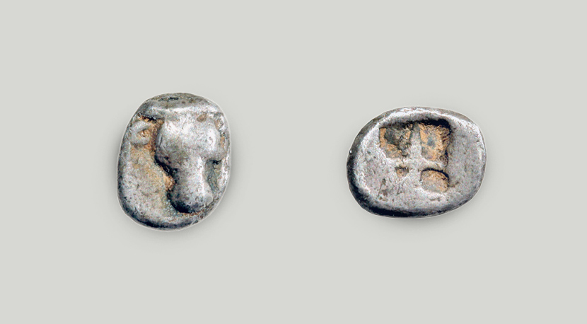 The obverse depicts a bull’s head. An incuse square is struck on the reverse.  Silver hemiobol, Athens, ca 550-530 BCE