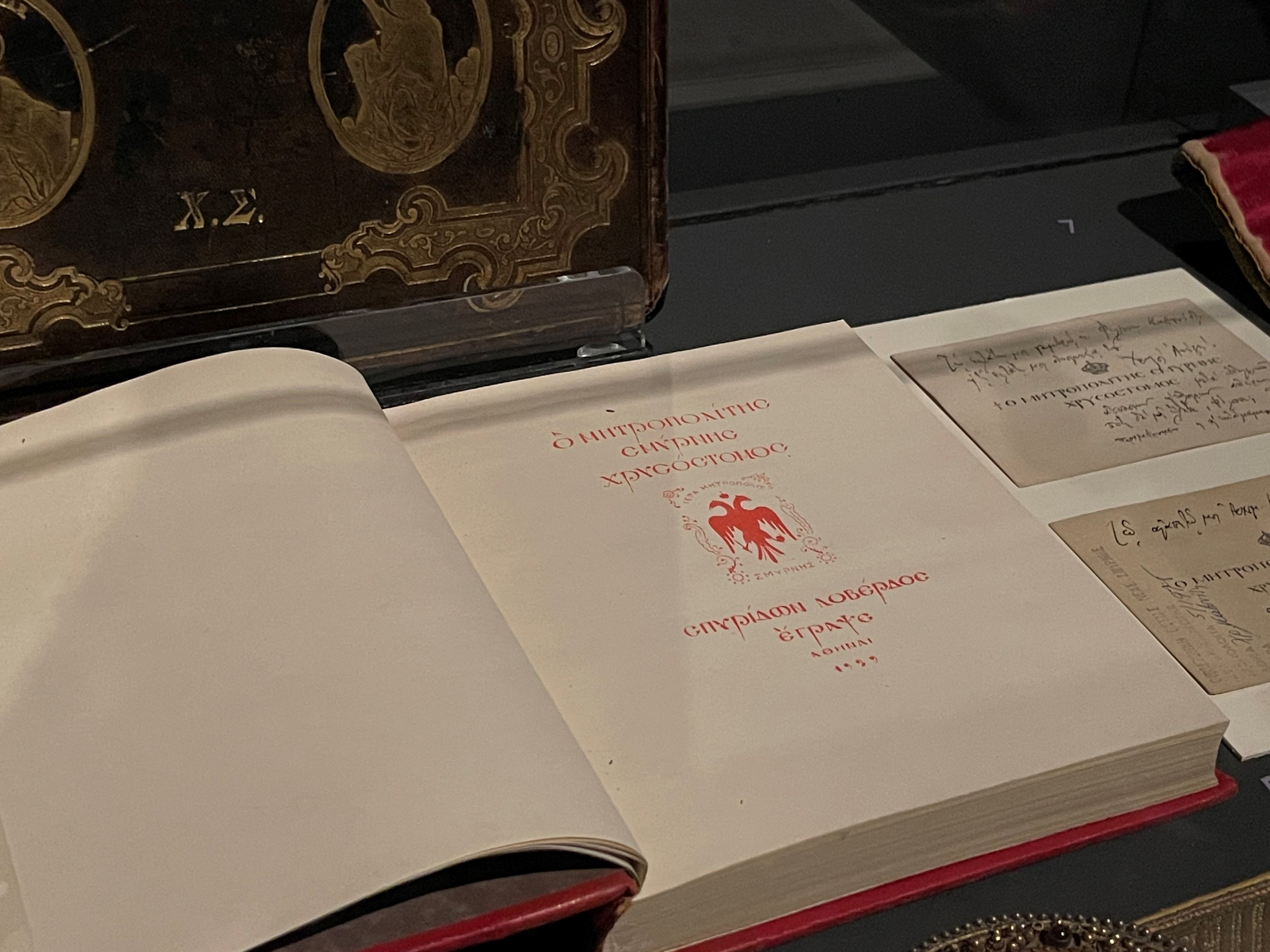 Title page from the book The Metropolitan Bishop Chrysostomos of Smyrna, with red two-headed eagle by Dimitris Galanis.  Participation “Asia Minor: Splendour – Catastrophe – Uprooting – Regeneration”