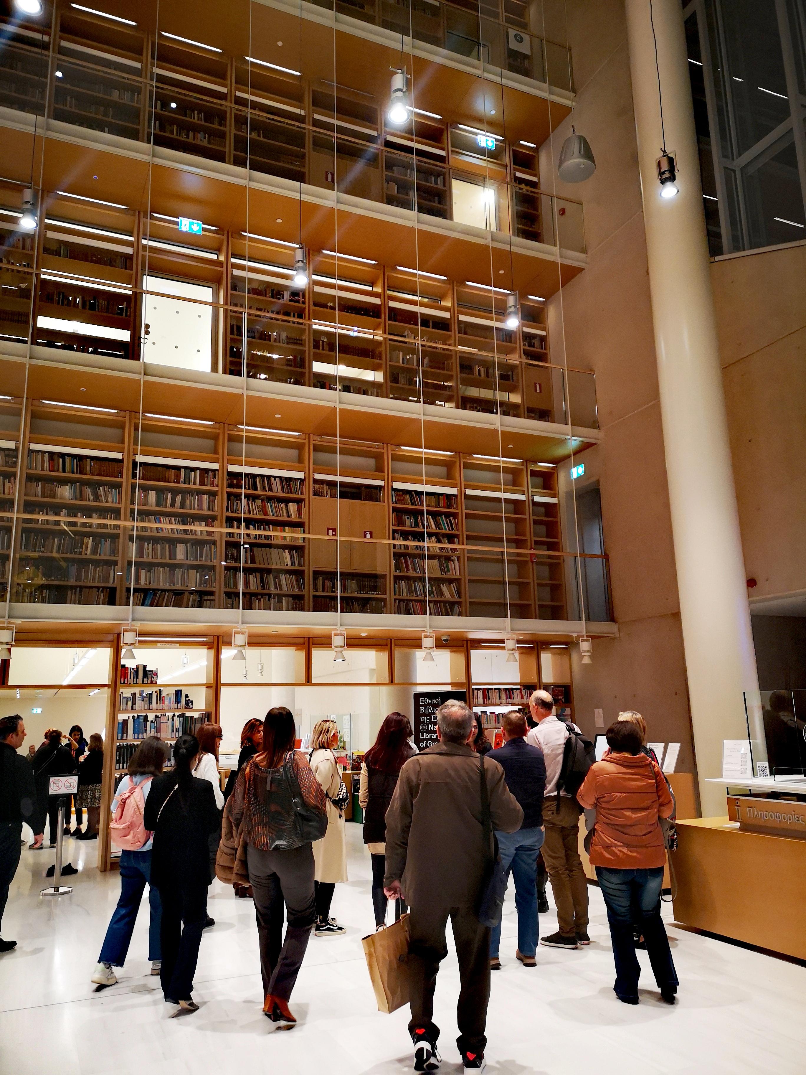 Alpha Bank employees being guided through the NLG. In the background, 3 floors of books. Highlight from the guided tour