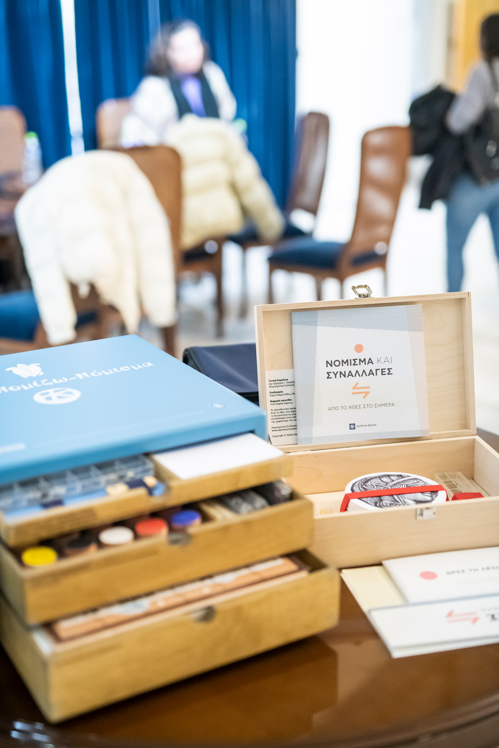 The 2 Alpha Bank Numismatic Collection museum kits on a table. Museum kits at the Kyriakopouleio Cultural Centre in Itea