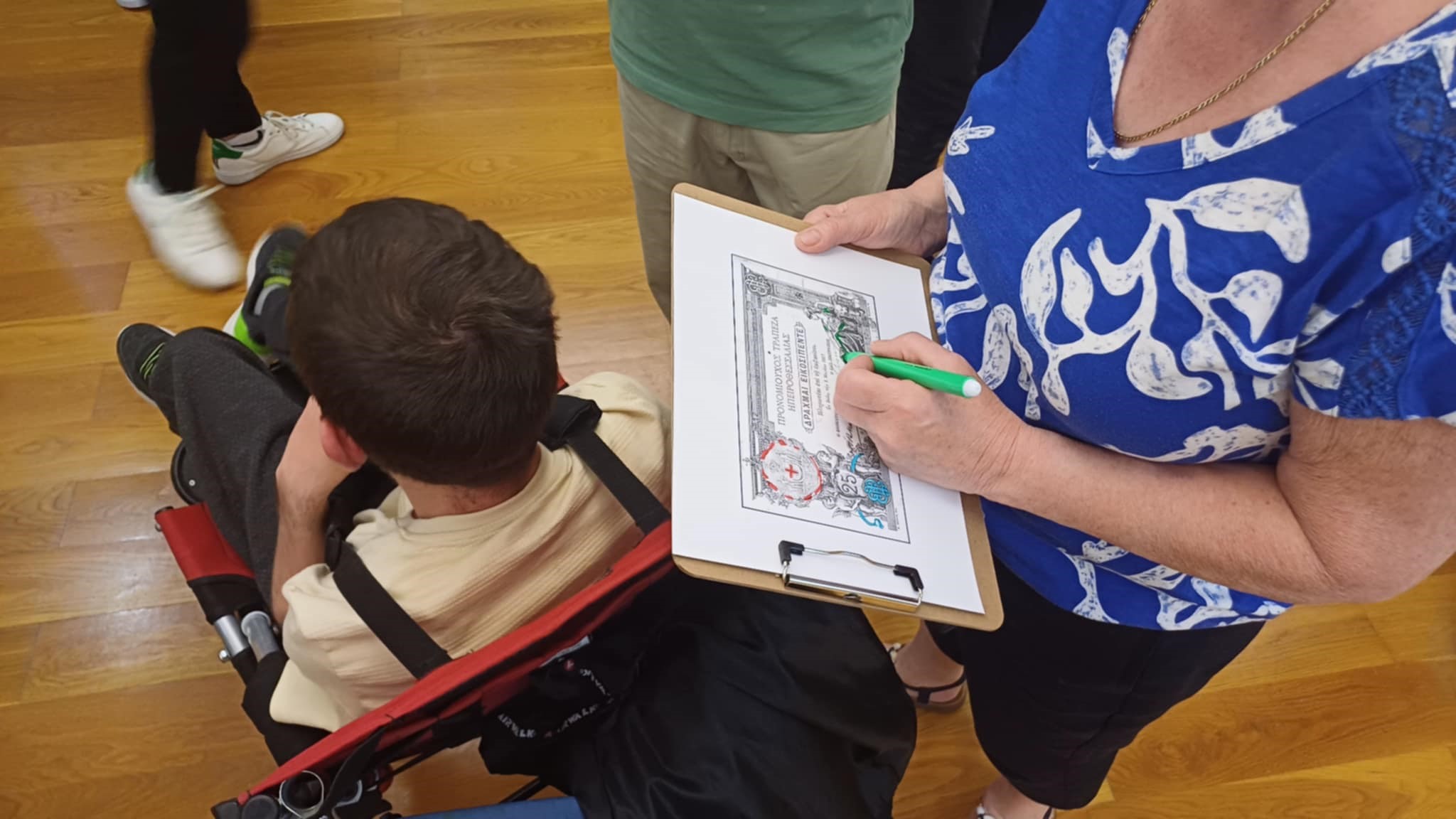 Women from the Corfu Soroptimist Club examining banknote replicas on a display case. Highlight from educational activity