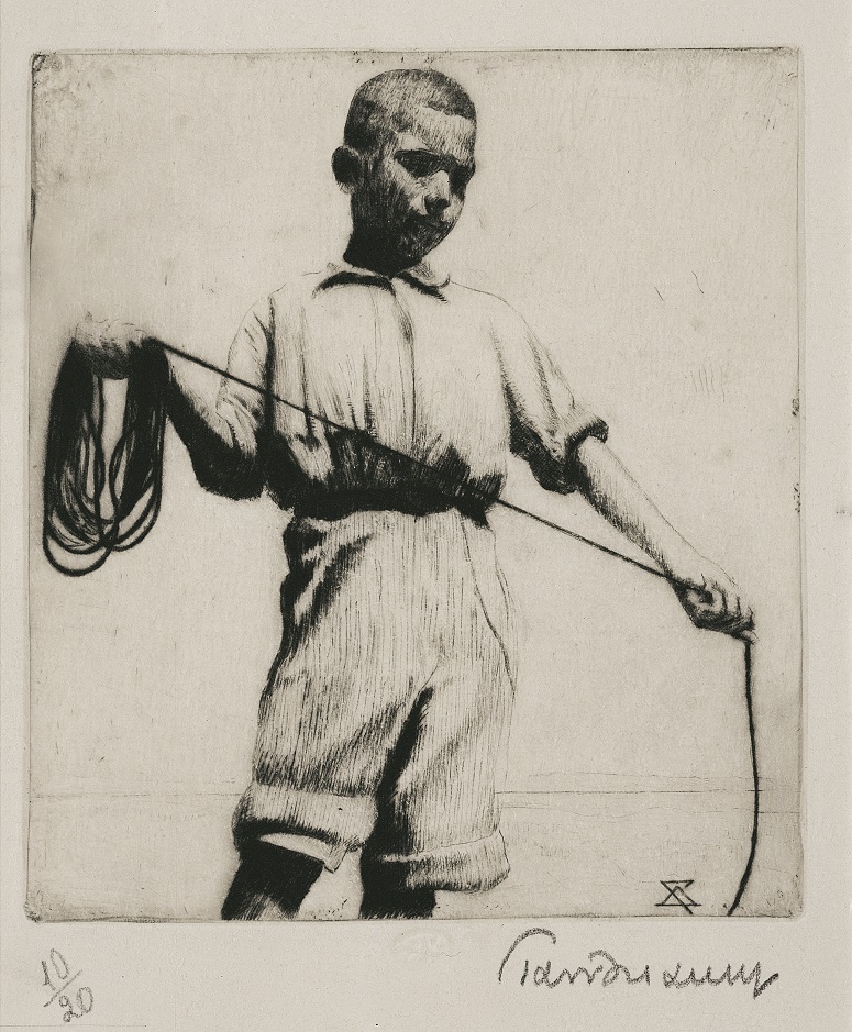Young boy standing, holding a coiled rope in one hand and uncoiling it with the other. 