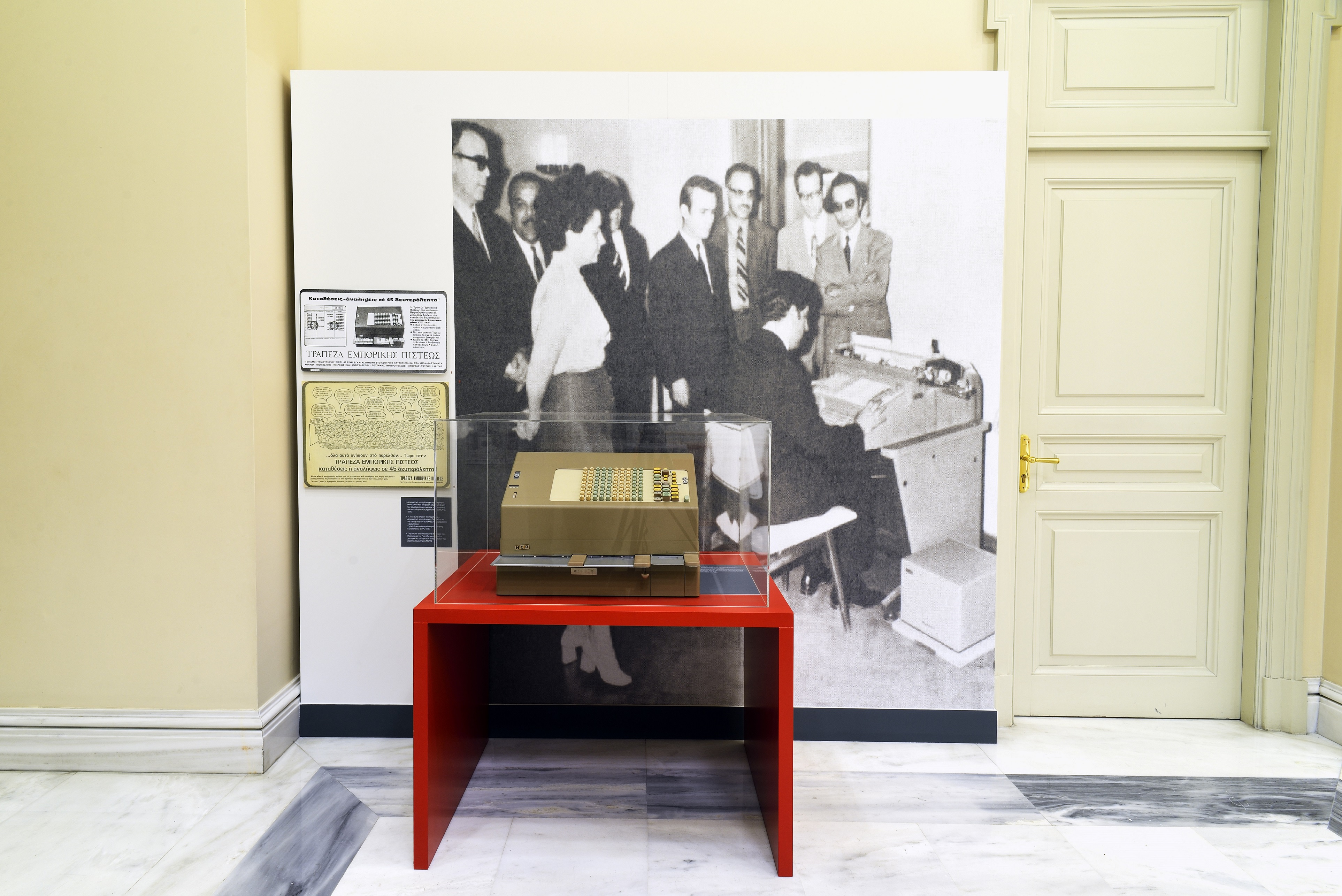 Teller Machine in a display case.  Teller machine from the exhibition “Alpha Bank/History ΙΙ: Commercial Credit Bank, 1947-1972”