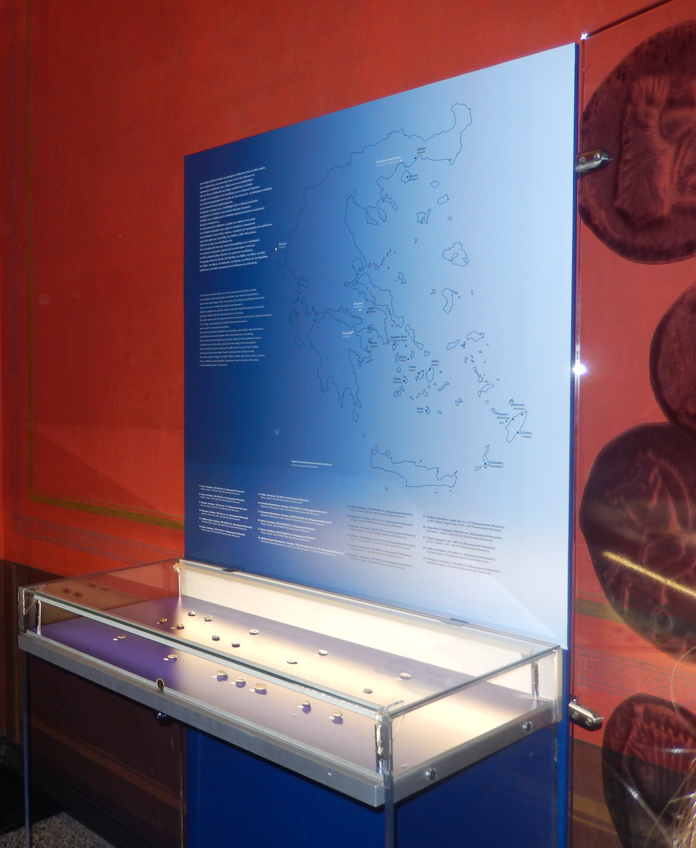 Display case and map of Greece.  Items from the exhibition “Athenian Archaic Coinage”