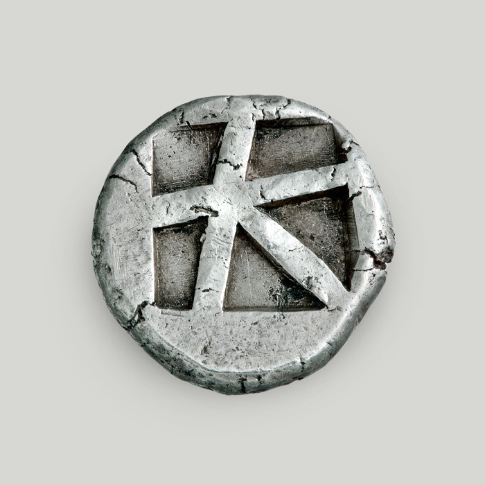 Reverse of Aegina silver stater depicting an incuse square split into 5 sections. 
