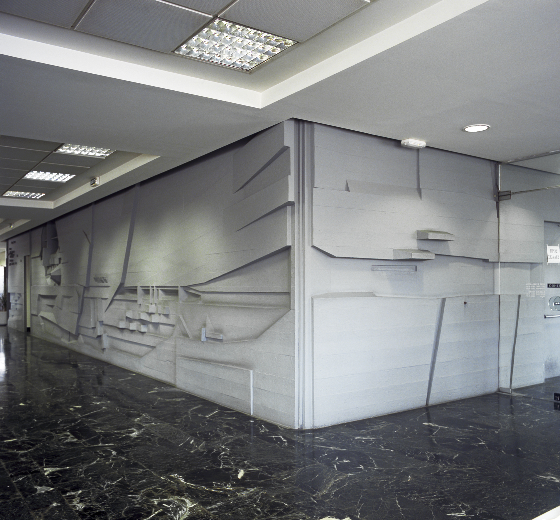 Wall relief by Cosmas Xenakis at the present-day entrance to the Athens Tower branch. Recent picture of wall relief by Cosmas Xenakis