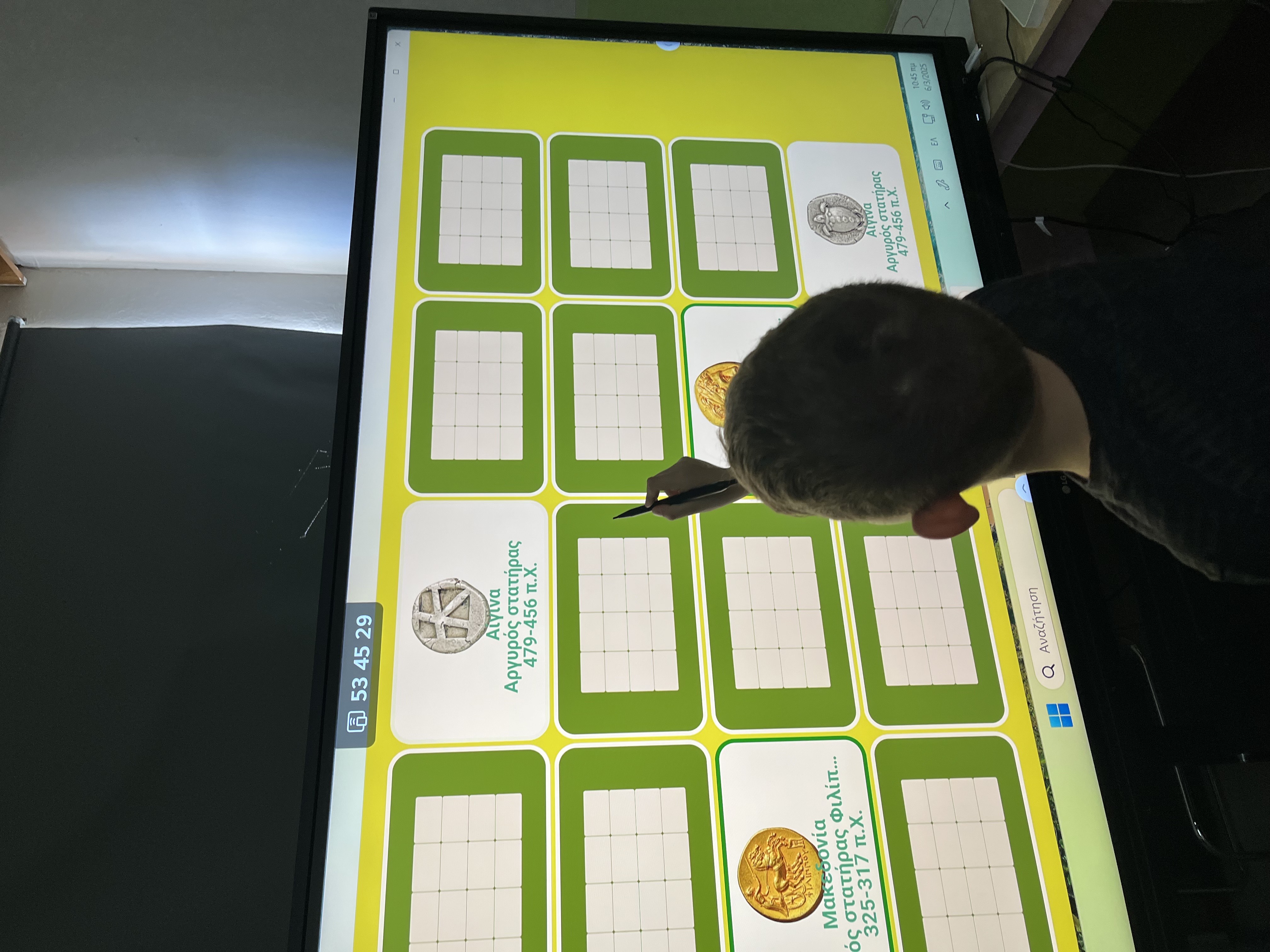 Student at an interactive screen participating in a digital activity. He’s holding a stylus. Snapshot from educational programme