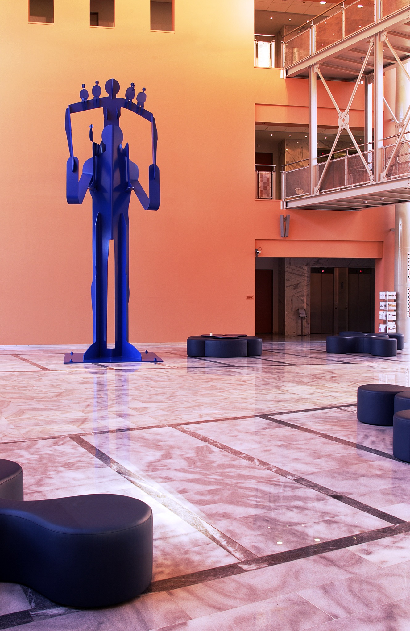 Μπλε κατασκευή με φιγούρα που κρατάει στους ώμους της μια άλλη που στηρίζει άλλες 5 μικρότερες.  Μπλε κατασκευή με φιγούρα που κρατάει στους ώμους της μια άλλη που στηρίζει άλλες 5 μικρότερες.