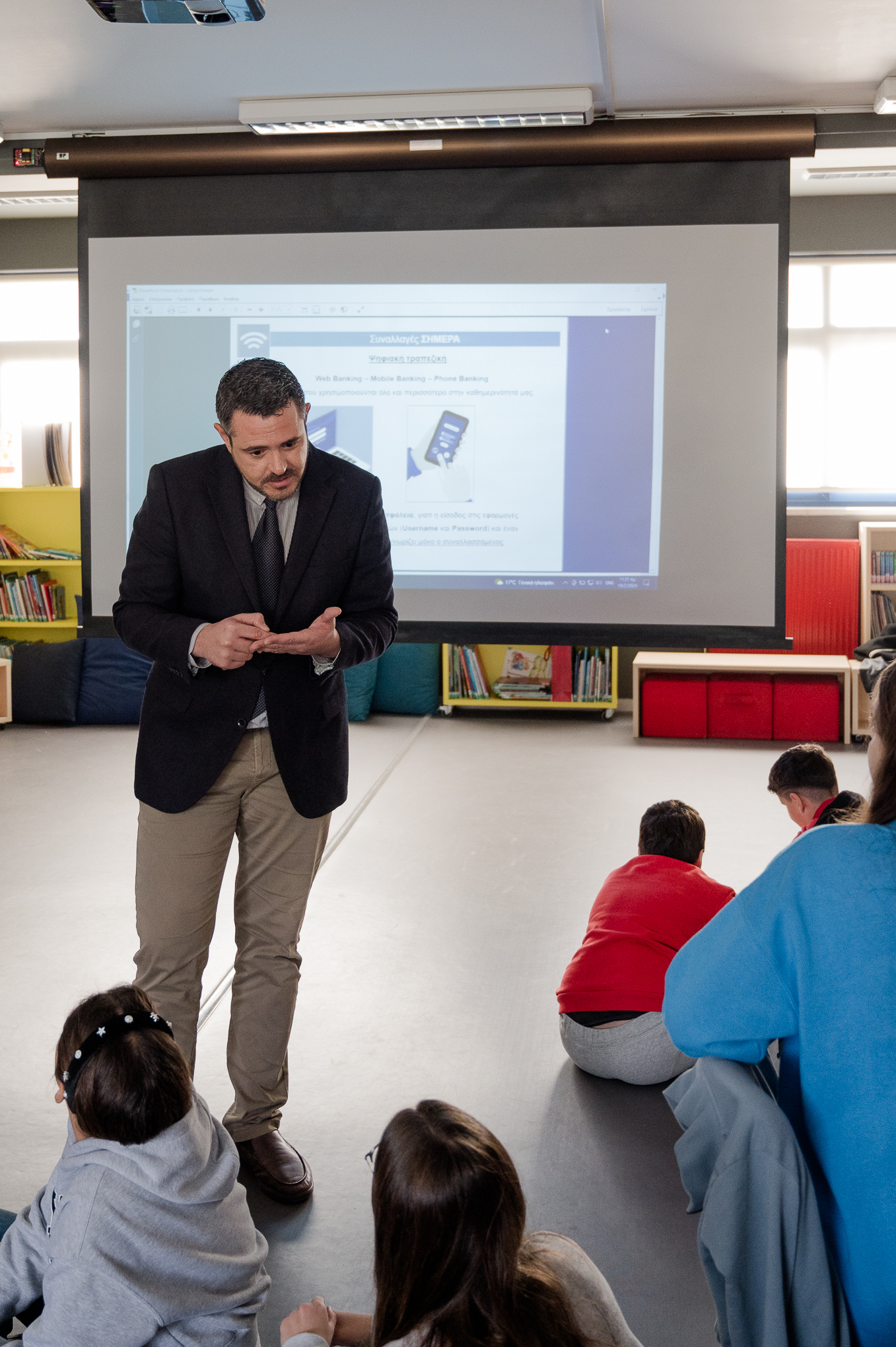 Mr Oikonomopoulos talking to children sitting on the floor. Highlight from the presentation