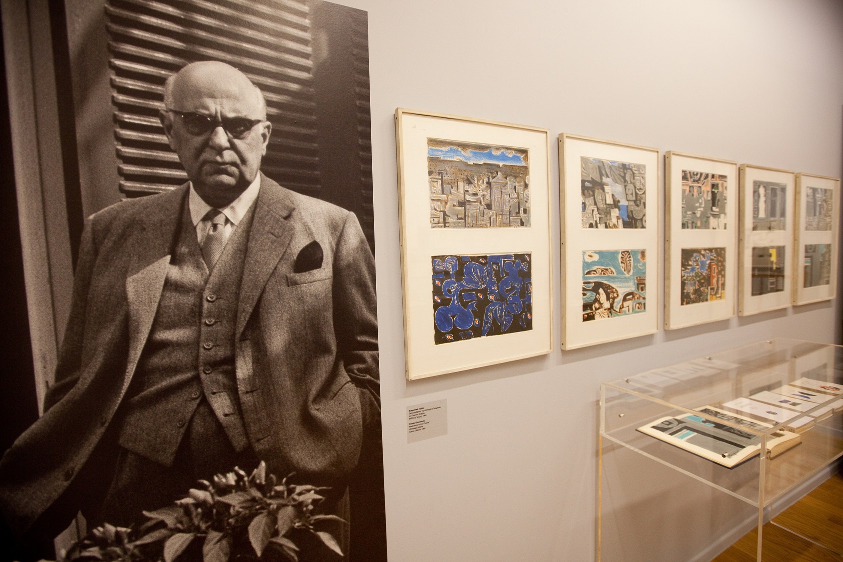 A picture of Yannis Moralis along with his paintings.  Yannis Moralis and works, exhibition “Yannis Moralis. Theatre-Music-Poetry”