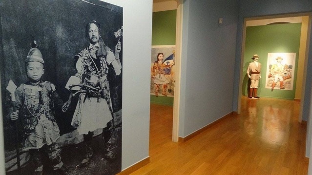 Picture of man and child on the left, painting of 1821 war hero behind wall, and 3D figure and painting at back.  Exhibits from the exhibition “Theophilos the painter”