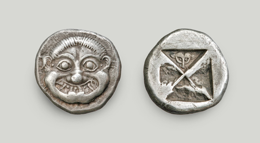 The obverse depicts a stylised Gorgon head. Incuse square struck on the reverse, with a lion’s head in one of the triangular sections.  Silver didrachm, Athens, ca 525-520 BCE