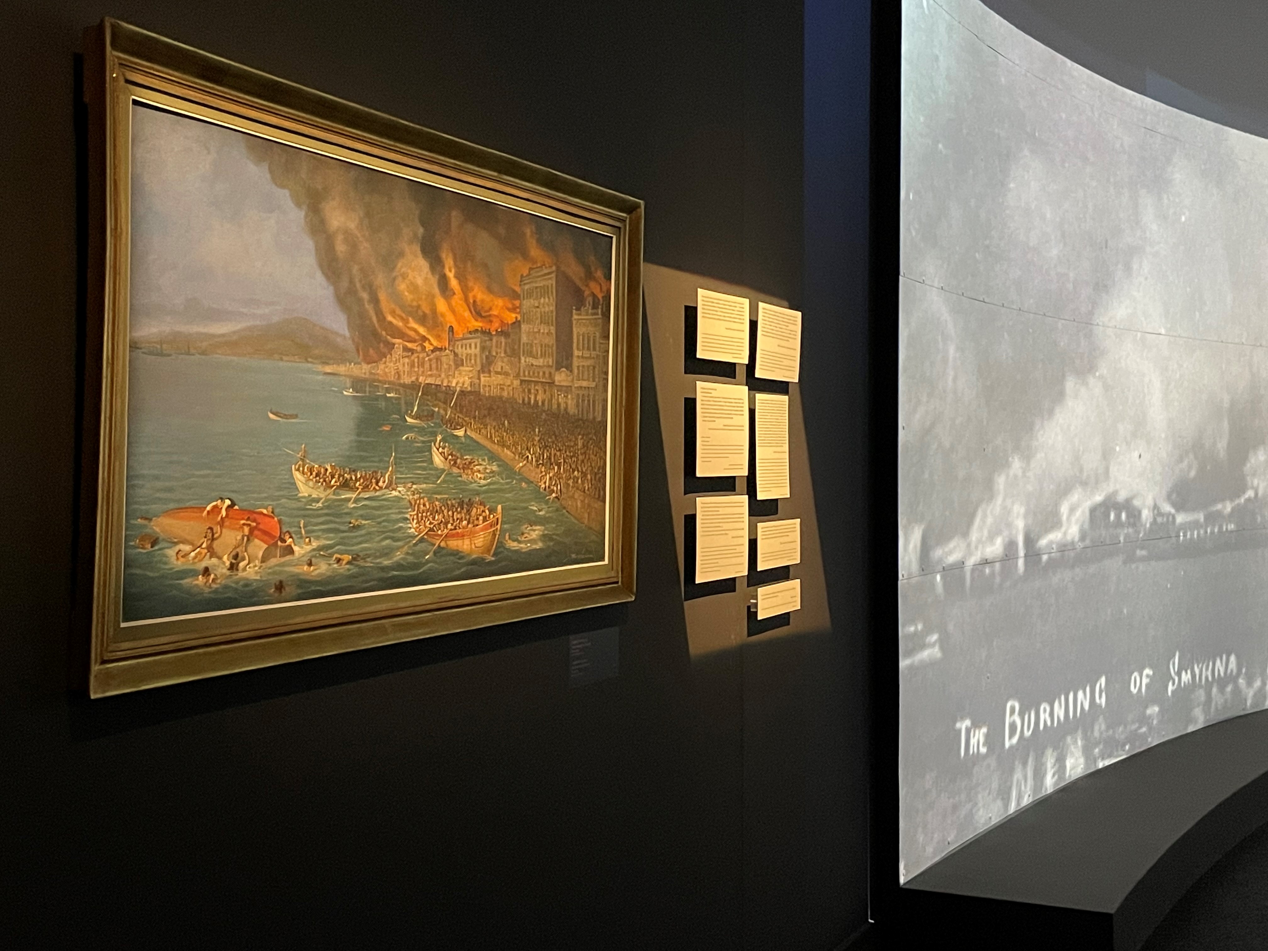 Painting and on the right screening of the burning of Smyrna taken from the dock.  Participation “Asia Minor: Splendour – Catastrophe – Uprooting – Regeneration”