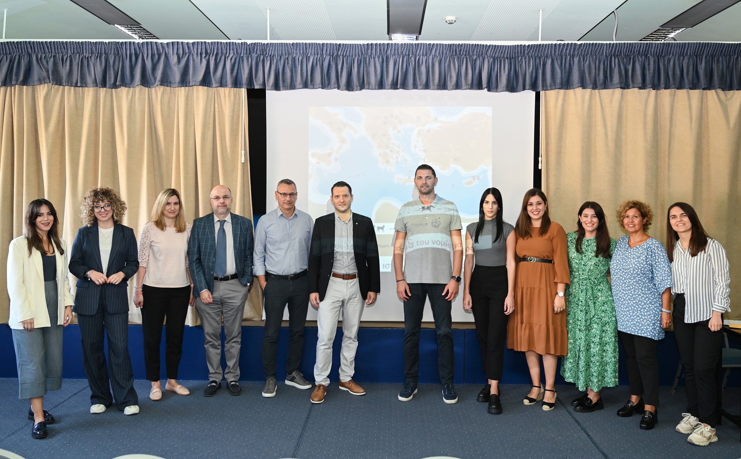 Students seated on the floor placing coins on a map of ancient Greece. Highlight from the activity